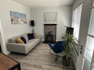 a living room with a couch and a fireplace at 2 hunters lane Donaghadee in Donaghadee