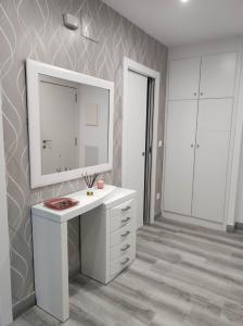 a bathroom with a white sink and a mirror at Piso marinero in Muxia