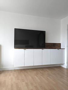 un centro di intrattenimento bianco con TV a schermo piatto di Appartement 3 Chambres - 78m2 - Lumineux a Bihorel