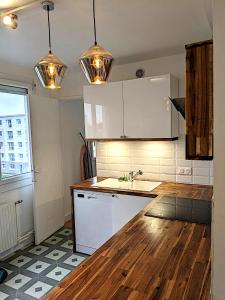 una cucina con armadietti bianchi e pavimenti in legno di Appartement 3 Chambres - 78m2 - Lumineux a Bihorel