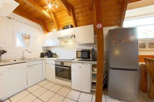 uma cozinha com electrodomésticos brancos e um tecto de madeira em Strandvogt 2 OH29 em Dorum Neufeld