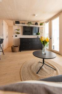 ein Wohnzimmer mit einer Blumenvase auf dem Tisch in der Unterkunft BUQEZ ECOVILLA 59 - DELPHINA in Drage