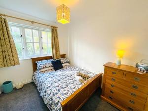 a bedroom with a bed and a dresser and a window at Centrally located "Spring Cottage" Perfect Ventnor Holiday Home in Ventnor