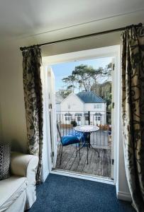 um quarto com uma porta que abre para um pátio com uma mesa em Centrally located "Spring Cottage" Perfect Ventnor Holiday Home em Ventnor