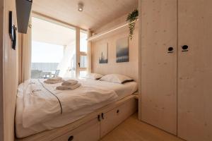 ein Schlafzimmer mit einem großen Bett und einem großen Fenster in der Unterkunft BUQEZ ECOVILLA 59 - DELPHINA in Drage