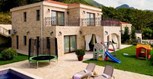 ein Haus mit einem Spielplatz davor in der Unterkunft Oak Leaf Residences in Budva