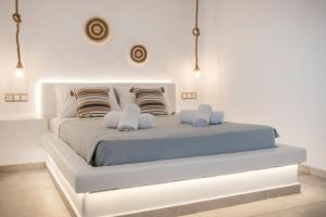 a white bedroom with a large white bed with pillows at Feel Breeze in Mikonos