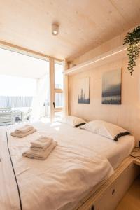 ein großes weißes Bett in einem Zimmer mit Fenster in der Unterkunft BUQEZ ECOVILLA 59 - DELPHINA in Drage