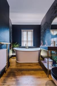 a bath tub in a bathroom with blue walls at Beautiful 4-bed Luxury Windsor Home by Casa by Grace, Amazing location, Perfect for large groups, Pet Friendly, sleeps 7-9! in Windsor