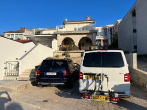 ein weißer Van neben einem schwarzen Auto geparkt in der Unterkunft Apartments By The Sea in Pula