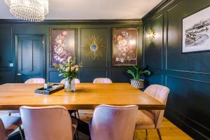 a dining room with a wooden table and chairs at The Windsor Tapestries Retreat - Sleeps up to 9, Hot Tub, Free Parking, Dog Friendly in Windsor