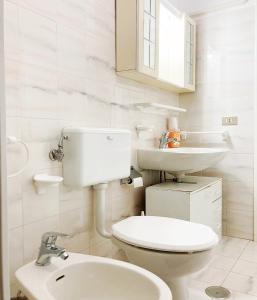 ein weißes Bad mit einem WC und einem Waschbecken in der Unterkunft Villetta Torre Vado in Torre Vado