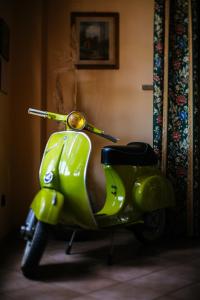 un scooter vert citron garé dans une chambre dans l'établissement Agriturismo Terra Di Dio Toscanizzazione, à Capannoli