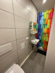 a bathroom with a colorful shower curtain and a toilet at Reeperbahn Apartments in Hamburg