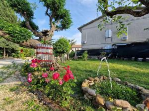 a garden with flowers and a tree and a house at La casetta di Flo in Montecosaro