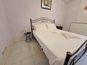 a bedroom with a large bed with white sheets and pillows at La casetta di Flo in Montecosaro