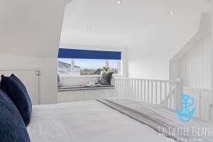 a white bedroom with a bed and a window at Seaway Garden in Paignton