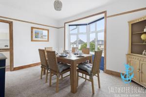 a dining room with a table and chairs and a window at Seaway Garden in Paignton