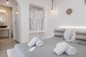 a white bedroom with towels on a bed at Feel Breeze in Mýkonos City +67 photos
