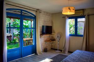 a bedroom with a blue door and a television at Casa Babalahy in Saint-Pierre