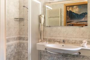La salle de bains est pourvue d'un lavabo et d'un miroir. dans l'établissement Hotel City Verona, à San Giovanni Lupatoto