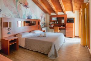 a bedroom with a large bed and a desk at Hotel City Verona in San Giovanni Lupatoto