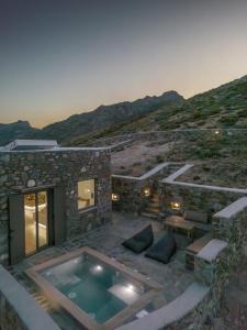 una casa de piedra con piscina en una colina en Petrias Pool House en Serifos Chora