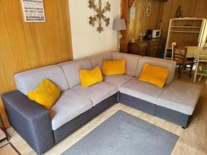 a living room with a couch with yellow pillows at Maison kertoff 41D in Gérardmer