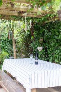Secluded Spacious Garden Suite في شيشستر: زجاجة من النبيذ موضوعة على طاولة مع كوب