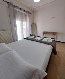a bedroom with two beds in a room with a window at Golden Sunrise - Nikos Home in Gythio