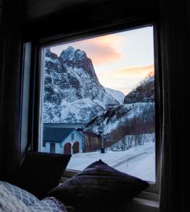 una ventana con vistas a una montaña nevada en Segla Guesthouse - Lovely sea view, en Fjordgård