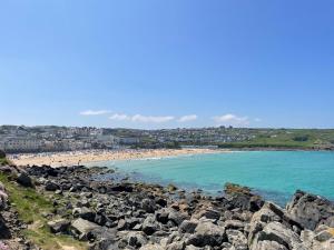 a view of a beach with people in the water at Coachhouse in St Ives