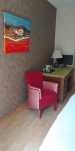 a room with a desk and a red chair at Loge & Broc in La Possonnière