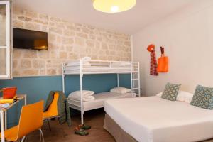 Zimmer mit 2 Betten und 1 Etagenbett in der Unterkunft Le Regent Montmartre by Hiphophostels in Paris