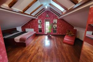 a bedroom with a bed and red walls and wooden floors at Casa in Oradea ! in Oradea