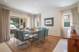 Un comedor con una mesa y sillas verdes. en VILLA SIBLING 2, en Vilamoura