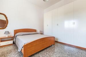 a bedroom with a wooden bed and a mirror at Salentoandmore - Bilocale Sole in Marina di Leuca