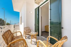 a patio with chairs and a table on a balcony at Salentoandmore - Bilocale Sole in Marina di Leuca