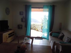 a living room with a couch and a sliding glass door at Roc A Mare in Galeria