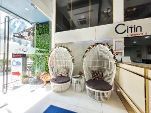 two white wicker chairs in front of a store at Citin Sukhumvit 11 Nana Bangkok by Compass Hospitality in Bangkok