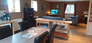 l'Heure bleue في آيويل: مطبخ وغرفة معيشة مع طاولة وكراسي