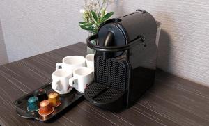 a coffee maker on a tray with cups and a vase at Hotel Logos Kraków in Krakow