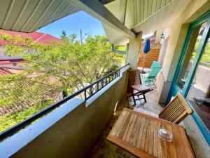 a balcony with a wooden table and chairs on a house at H by Hambar in Vama Veche