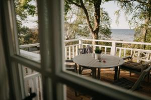 a window view of a table and chairs on a balcony at Jūras māja Ausekļi in Kaltene