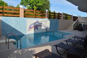 a swimming pool with a mural of an umbrella at Thassos Grand Villas Apartments & Studios in Limenaria