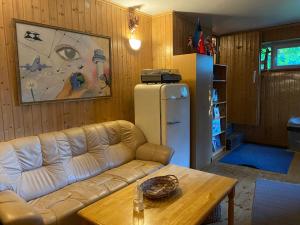 a living room with a couch and a table and a refrigerator at Tanuma Apartment in Tallinn
