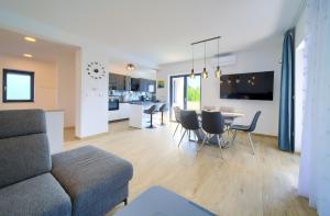 Una sala de estar y una cocina con un sofá y una mesa. en Apartments Paola & Karla with pool, en Krk