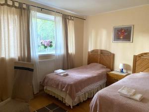 a bedroom with two beds and a window with flowers at Tanuma Apartment in Tallinn