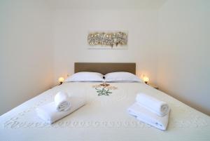 Un dormitorio con una cama con toallas blancas. en Apartments Paola & Karla with pool, en Krk 45 fotos más