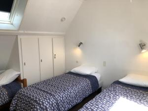 1 Schlafzimmer mit 2 Betten und einem Fenster in der Unterkunft Cromlech, Appartement avec petite vue mer, DT170 in Carnac
